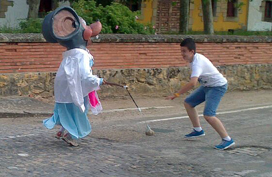Un cabezudo juega con un niño.