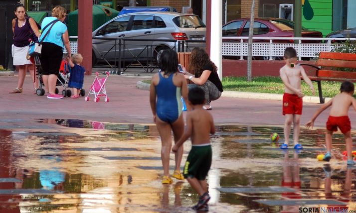 Unos niños se refrescan en las fuentes del centro cívico Bécquer. / SN