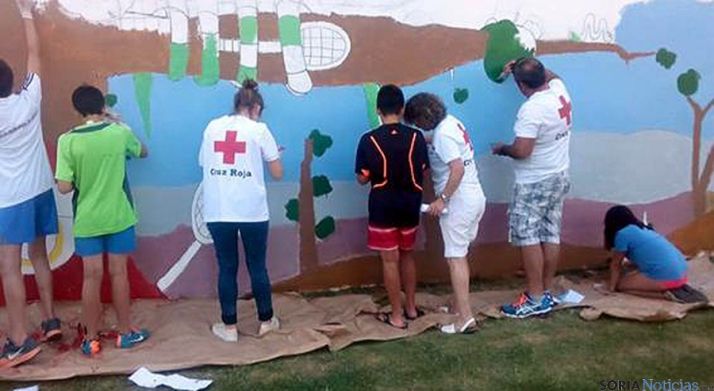 Pintura de un mural de Cruz Roja en la villa. 