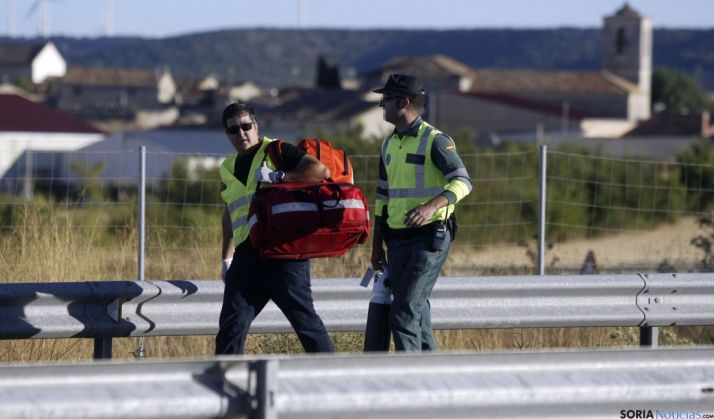 Un sanitario y un agente de la Guardia Civil acudiendo ayer al lugar del accidente. / SN