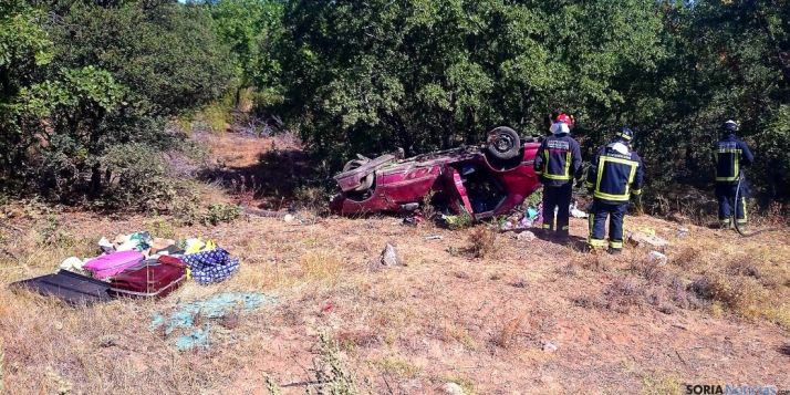 Los bomberos junto al vehículo siniestrado. / SN