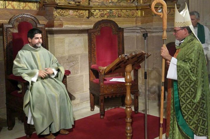 El presbítero, sentado, frente al obispo, durante el nombramiento. /DOS