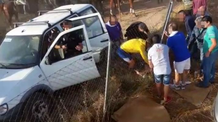 Un grupo de personas y agentes del CNP atienden al corneado. 