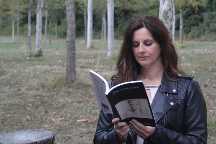 Cristina Romea lee Pan con vino y azúcar, su obra situada en Peñalcázar. Cedida 