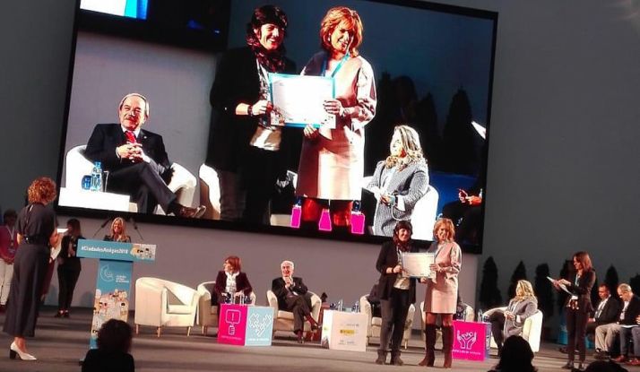 Ana Alegre, en la pantalla a la izquierda, recibe el premio. /Ayto.