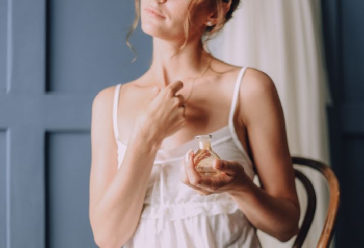 Mujer perfumándose. 