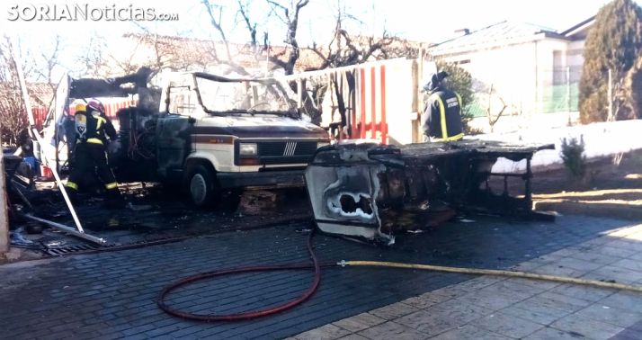 Los bomberos con el vehículo calcinado. /SN