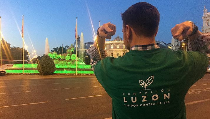 Un paciente de ELA ante la Cibeles de Madrid iluminada de color verde. 