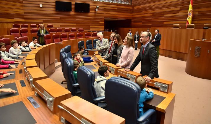 El presidente de las Cortes de Castilla y León, Luis Fuentes, y el resto de las autoridades recibe a un grupo de escolares en el hemiciclo tras la firma del convenio con la Consejería de Educación. 
