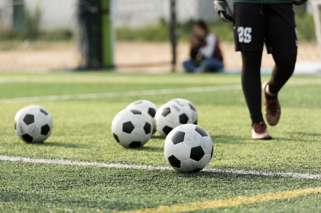 Campo de fútbol y balones sobre el verde.