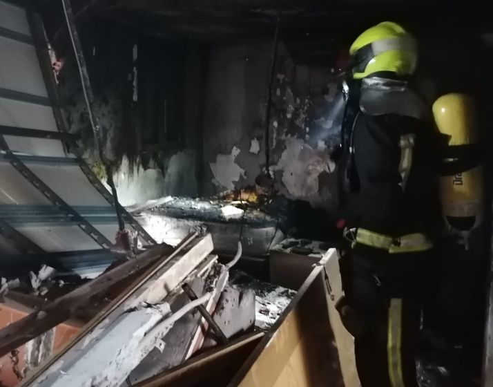Un bombero trabaja en la vivienda que ha sufrido la explosión.