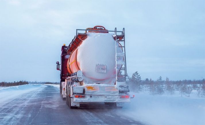 Un vehículo articulado circulando por una carretera convencional tras una nevada. 