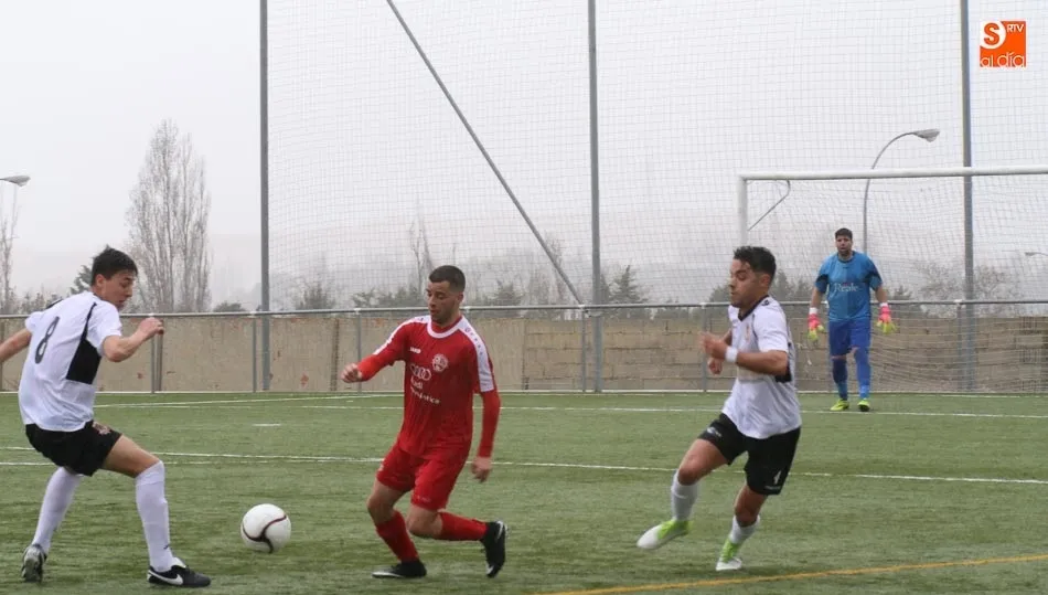 Un jugador del Hergar intenta avanzar con el balón ante dos rivales. Fotos: Alberto Martín