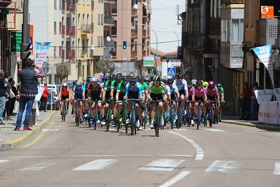 El pelotón de la Vuelta Ciclista a Castilla y León a su paso por la meta volante de Guijuelo