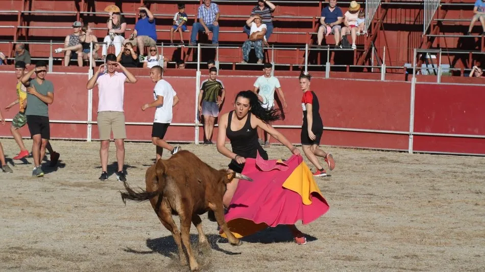 Una joven da un pase a una vaquilla ante el seguimiento de los asistentes. Fotos: Alberto Martín