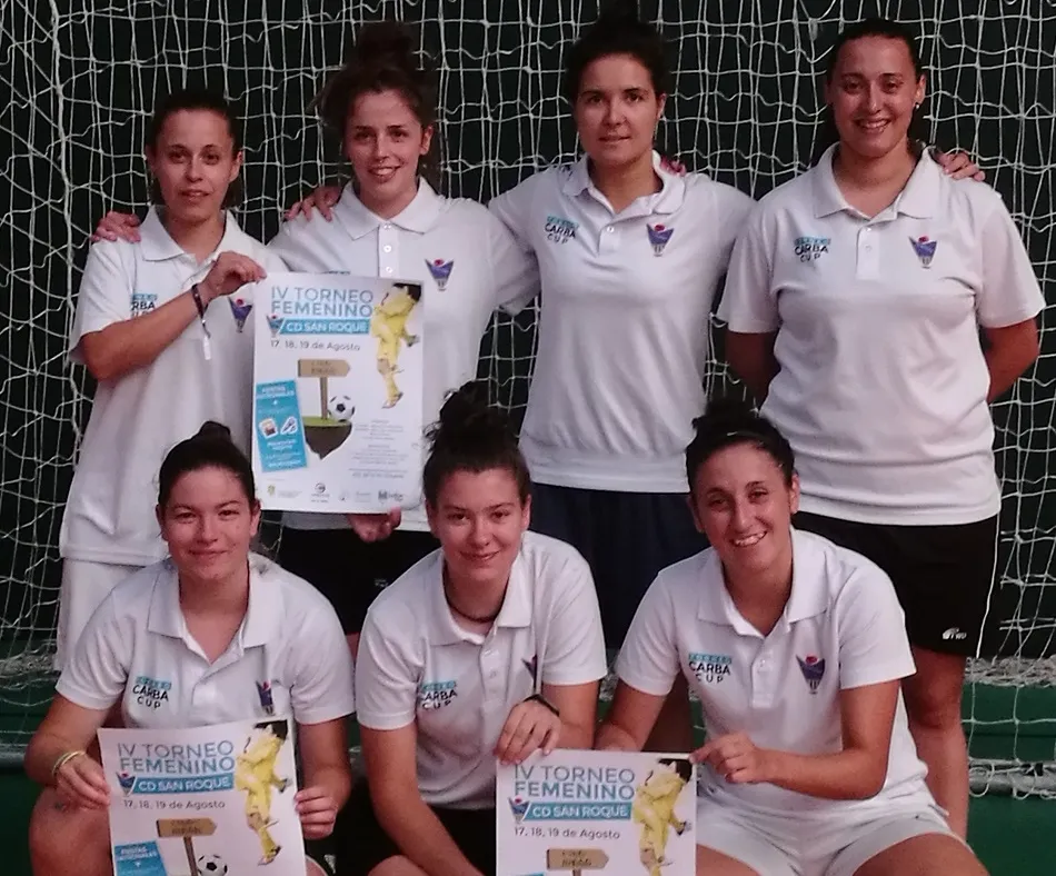 Las jugadoras del equipo regional posan con el cartel del torneo de fiestas.