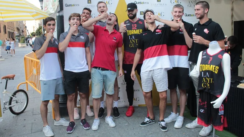 Los jugadores prueban el queso del patrocinador durante el acto promocional.