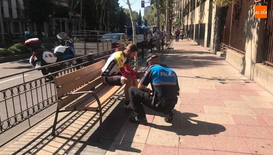 Un agente de la Policía Local se preocupa por el ciclista lesionado. Foto de Ángel Merino