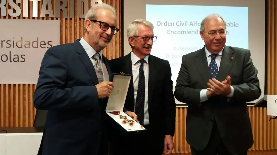 El ex rector muestra la medalla recibida.