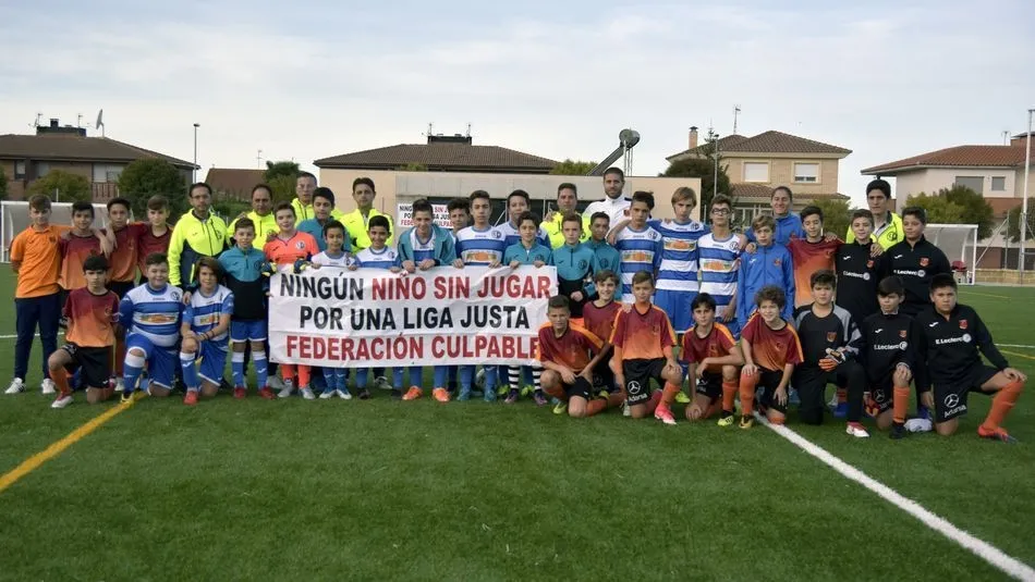 Jugadores de uno de los equipos portan una pancarta reivindicativa junto al Carbajosa.