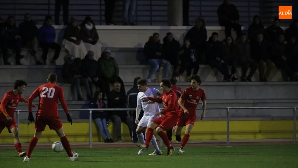 Nacho Sánchez intenta aguantar el balón ante una nube de rivales del Hergar. Fotos: Alberto Martín