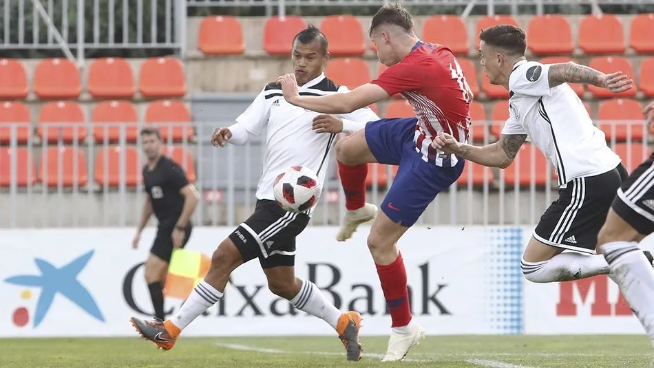 Rubén Garcés remata ante la oposición de Tyson y Toño Vázquez. Fotos: Atlético de Madrid