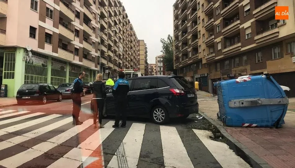 Agentes de la Policía Local junto a la conductora y el contenedor derribado. Foto de Ángel Merino