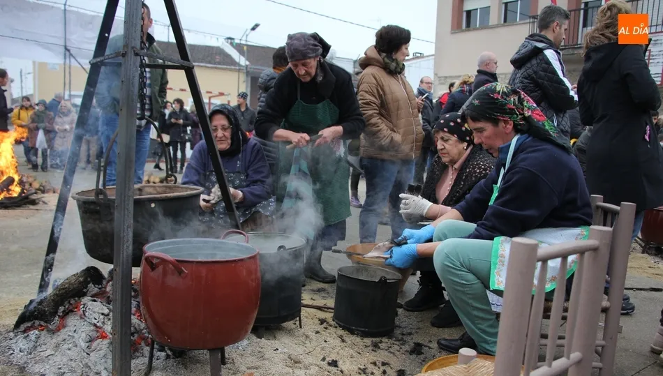 Las mujeres escaldando las patas y rabos de los cerdos sacrificados el año anterior