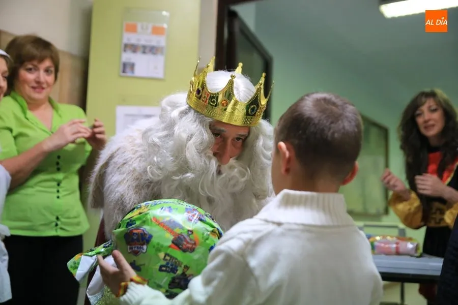 El Rey Melchor obsequia a un niño con un regalo / Foto: Alberto Martín.