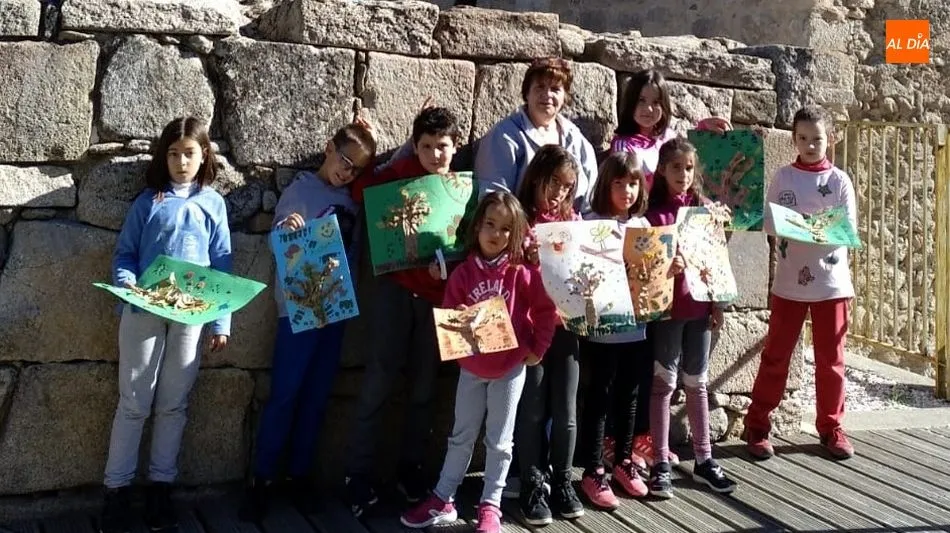 Un grupo de niños y una educadora muestran los trabajos realizados en un taller celebrado en el Torreón / E. Corredera