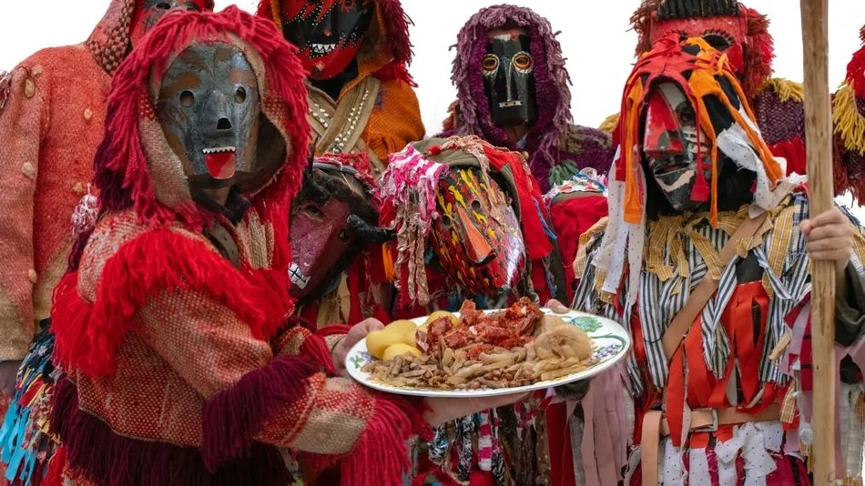 Caretos portando un plato de botillo con casulas