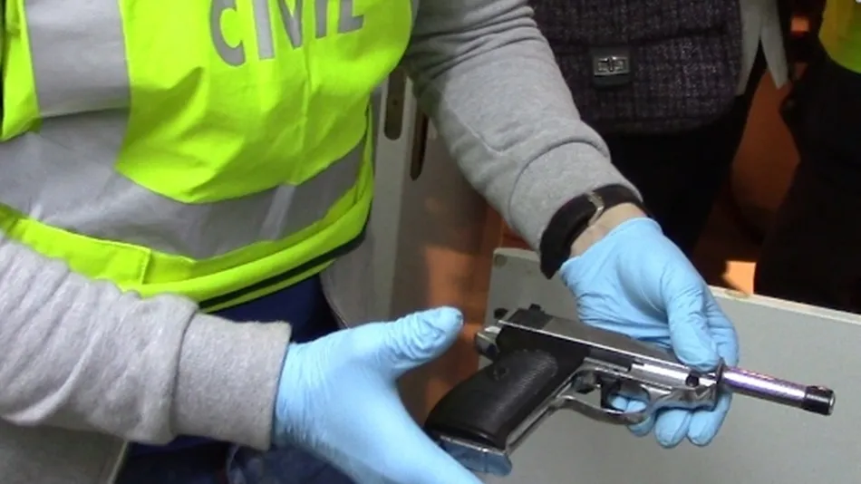 Imagen de archivo de un agente de la Guardia Civil con un arma incautada