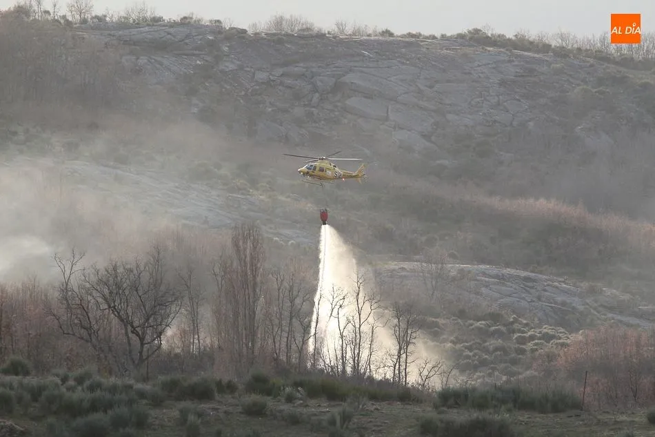 El helicóptero de extinción arroja agua sobre el incendio ya controlado