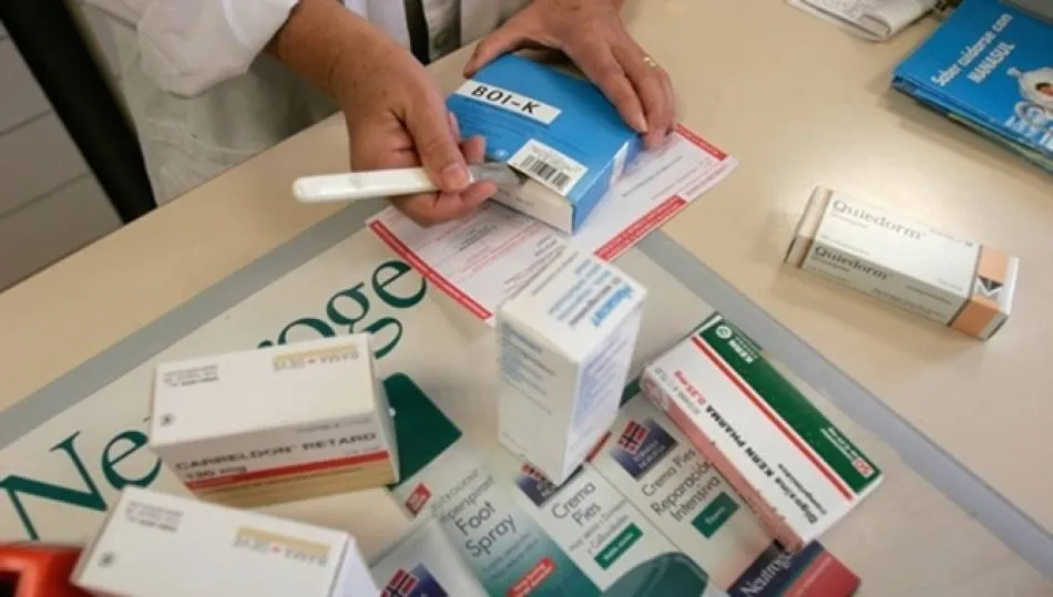 Una farmacéutica dispensando unos envases de medicamentos