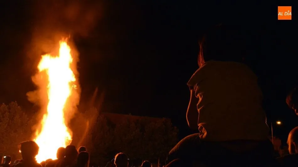 Una niña disfruta de la hoguera a hombros de su padre/ Lydia González