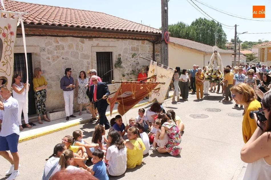 Los niños esperan sentados para recibir la protección de los estandartes y las imágenes del patrón y la Virgen.