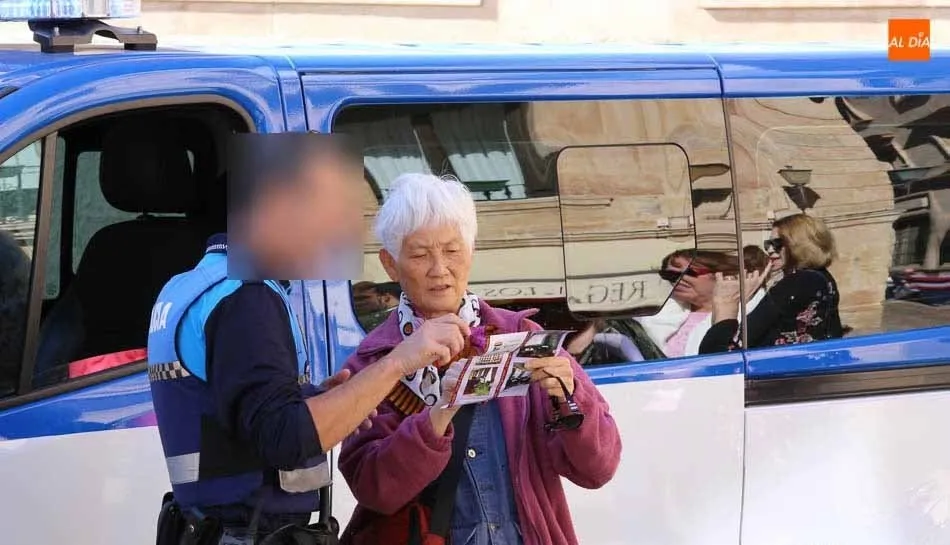 Un agente de la Policía Local atiende a una turista en el centro de Salamanca