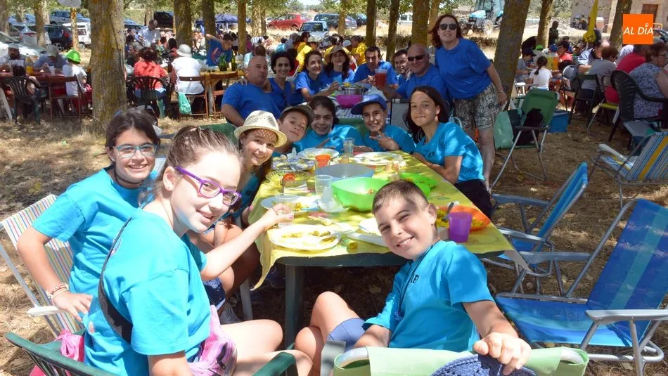 Pequeños y mayores se reúnen en torno a la paella bajo las sombra de los chopos / E. Corredera