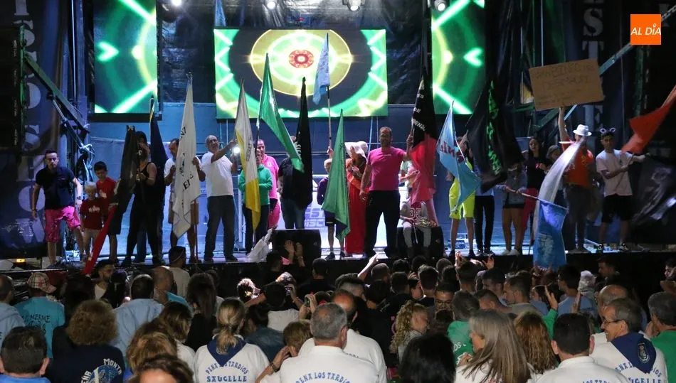 Las peñas colocaron sus banderas sobre el escenario para anunciar el inicio de las fiestas / CORRAL