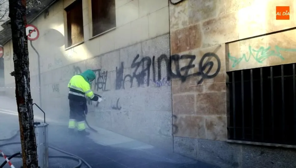 Operario del Ayuntamiento limpiando una pintada en la calle Santa Clara
