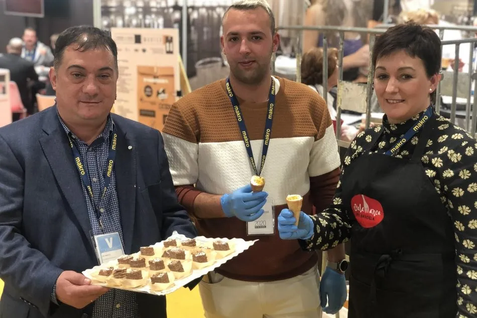 Fabián Martín (iz.) y Rosa Ramos posan junto a otro miembro de Pan de Ángel con las elaboraciones de la empresa en Madrid Fusión