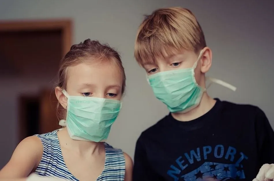 Dos niños, con mascarillas