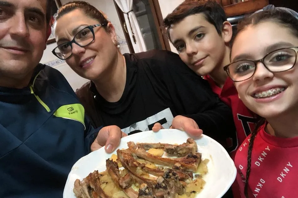 El presidente de ASAJA Salamanca, Juan Luis Delgado, con su familia y un plato de chuletillas de lechazo