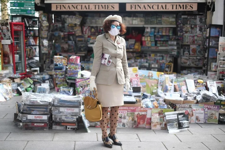 Una mujer con mascarilla frente a un kiosco en Madrid - Eduardo Parra Europa Press
