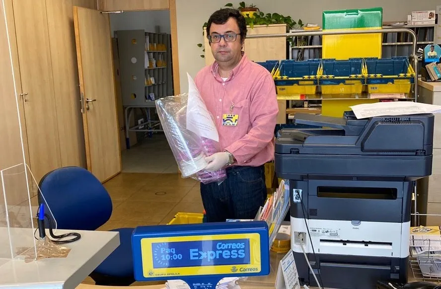 Uno de los empleados de Correos con un lote de pantallas protectoras de Resistencia Salamanca