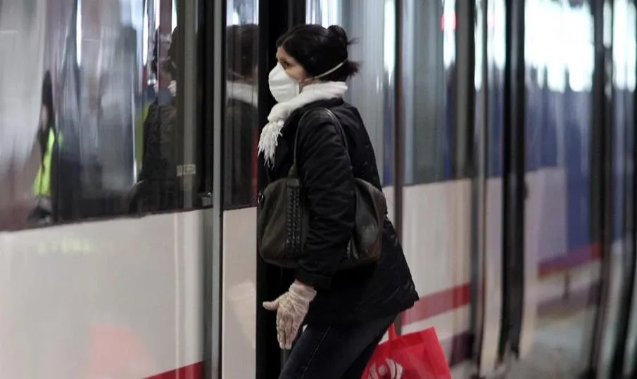 Viajera que entra en un tren de Cercanías de Atocha portando mascarilla. Foto de Eduardo Parra - EP