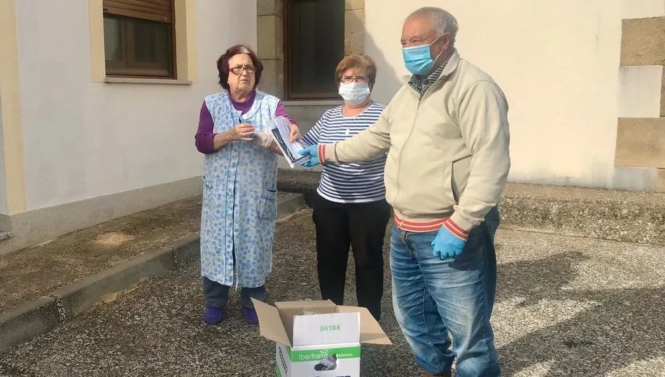 El alcalde de Guadramiro y una empleada municipal entregan el material higiénico a una vecina
