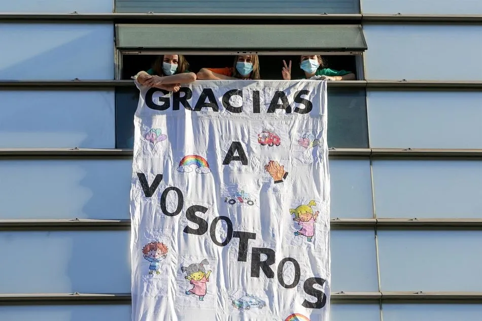 Tres sanitarias del Hospital General Universitario Gregorio Marañón en una ventana del hospital. - Ricardo Rubio - Europa Press