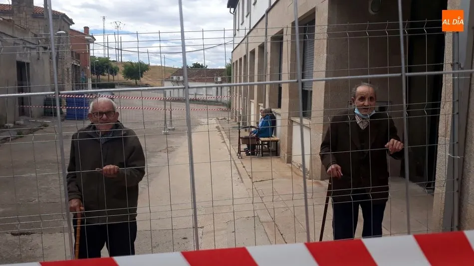 Dos residentes pasean en el recinto vallado en la calle la Iglesia