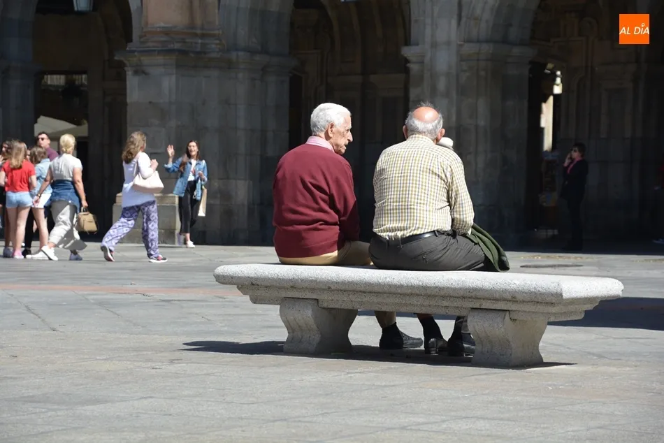 Imagen de archivo de varias personas mayores sentadas en un banco de la Plaza Mayor